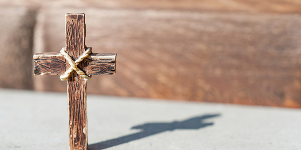 Mit einem Tau umwickeltes Holzkreuz, das einen Schaten wirft, © Zaharia Bogdahn