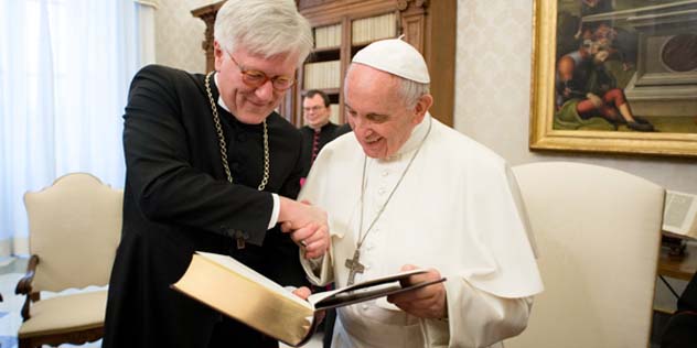 Landesbischof Heinrich Bedford-Strohm überreicht Papst Franziskus eine neue Ausgabe der Lutherbibel.