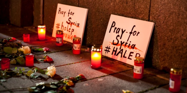 Blumen, Kerzen und Schilder: 'Pray for Syria! - Betet für Syrien'